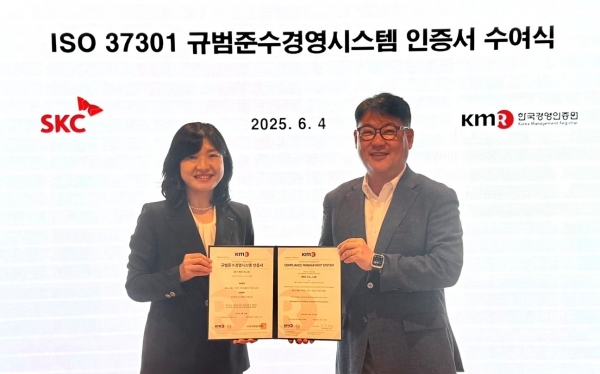 SKC가 한국경영인증원(KMR)으로부터 규범준수경영시스템 국제표준 ISO 37301 인증을 획득하고 기념촬영을 하고있다.(왼쪽부터 황은주 KMR 대표이사, 김윤회 SKC 컴플라이언스 본부장) [사진=SKC]