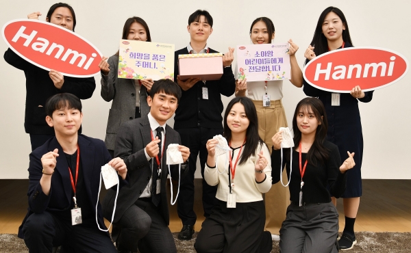 ▲한미사이언스와 한미약품 직원들이 소아암 환아를 위해 직접 제작한 히크만 주머니를 들고 기념촬영을 하고 있다