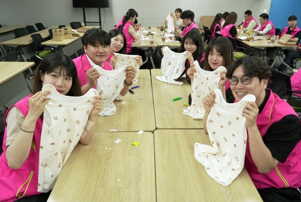 12일 서울 종로구 흥국생명 본사에서 임직원들이 미혼모 가정에 전달할 수면조끼 및 육아키트를 정성스럽게 만들고 있다. [사진=흥국생명]