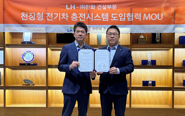 최한봉 LH 공공주택전기처장(왼쪽)과 박광호 한화 건설부문 건축지원실장(오른쪽)이 차세대 천장형 전기차 충전시스템 ‘EV에어스테이션’의 시범도입을 위한 협약을 체결하고 기념촬영을 하고 있다. [한화 건설부문]