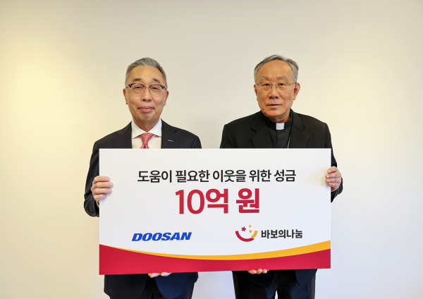 박지원 두산그룹 부회장(사진 왼쪽)과 구요비 재단법인 바보의 나눔 이사장이 3일 서울 명동성당에서 열린 성금 전달식에서 기념촬영을 하고 있다. [사진=두산그룹]