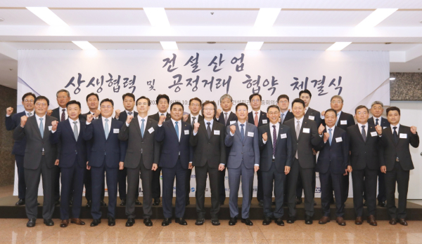 오일근 롯데건설 대표(두 번째 줄 오른쪽 5번째), 윤학수 전건협 회장(앞줄 왼쪽 다섯 번째), 주병기 공정거래위원장(앞줄 왼쪽 여섯 번째) 등 협약식 참석자들이 기념촬영을 하고 있다. [사진=대한전문건설협회]