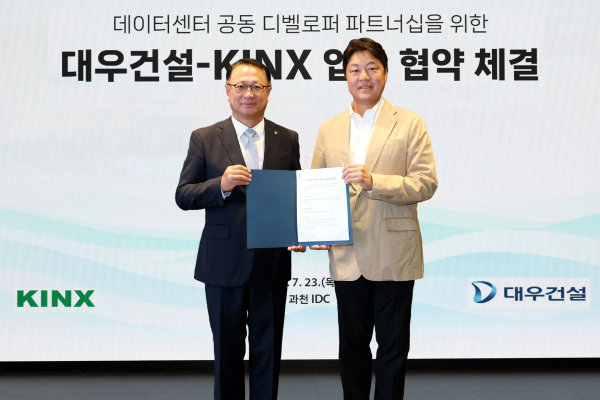 전용수 대우건설 건축사업본부장(왼쪽)과 김지욱 KINX 대표이사가 업무협약 체결 후 기념촬영 하고 있다. [사진=대우건설]