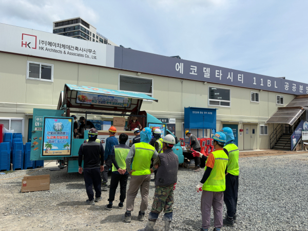 에코델타시티푸르지오트레파크현장 대우건설 뿌듯트럭에 근로자들이 줄을 서고 있다. [사진=대우건설]
