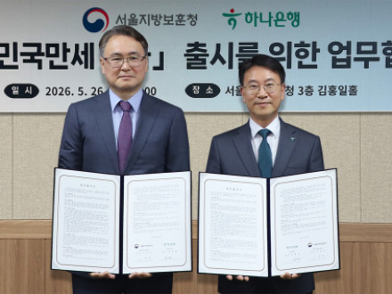 하나은행은 지난 26일 오후 서울 용산구 서울지방보훈청에서 호국보훈의 달을 맞아 ‘대한민국만세 적금’ 출시를 위한 업무협약을 체결했다. 이날 협약식에 참석한 김영호 하나은행 리테일그룹 그룹장(사진 오른쪽)이 이승우 서울보훈청장(사진 왼쪽)과 함께 협약서를 들고 기념촬영을 하고 있다. [사진=하나은행]