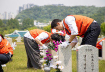 호반그룹 임직원들이 군인 묘역에서 비석을 닦고 있다. [사진=호반그룹]